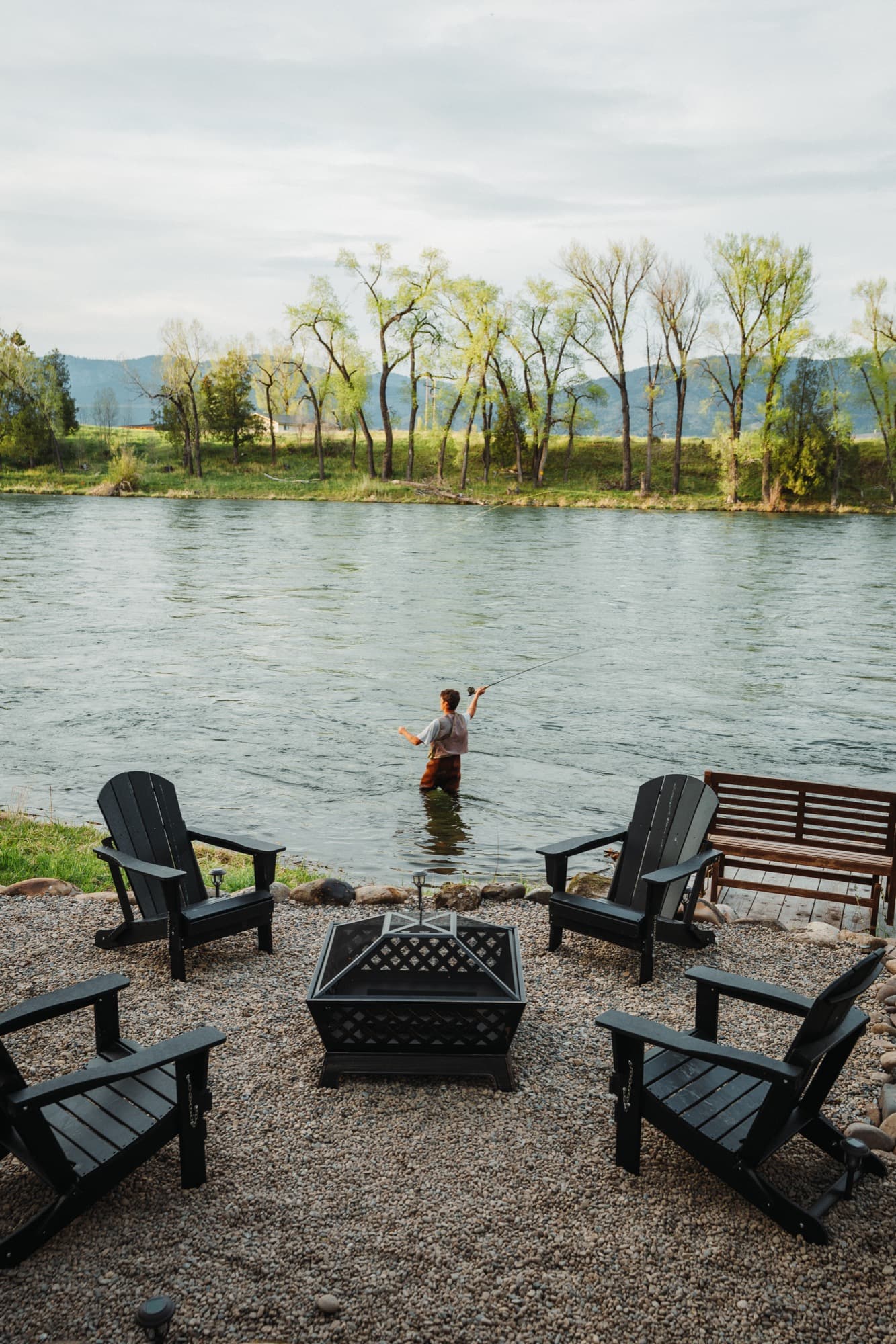 Angler fly fishing the Snake River steps from the cabin's firepit
