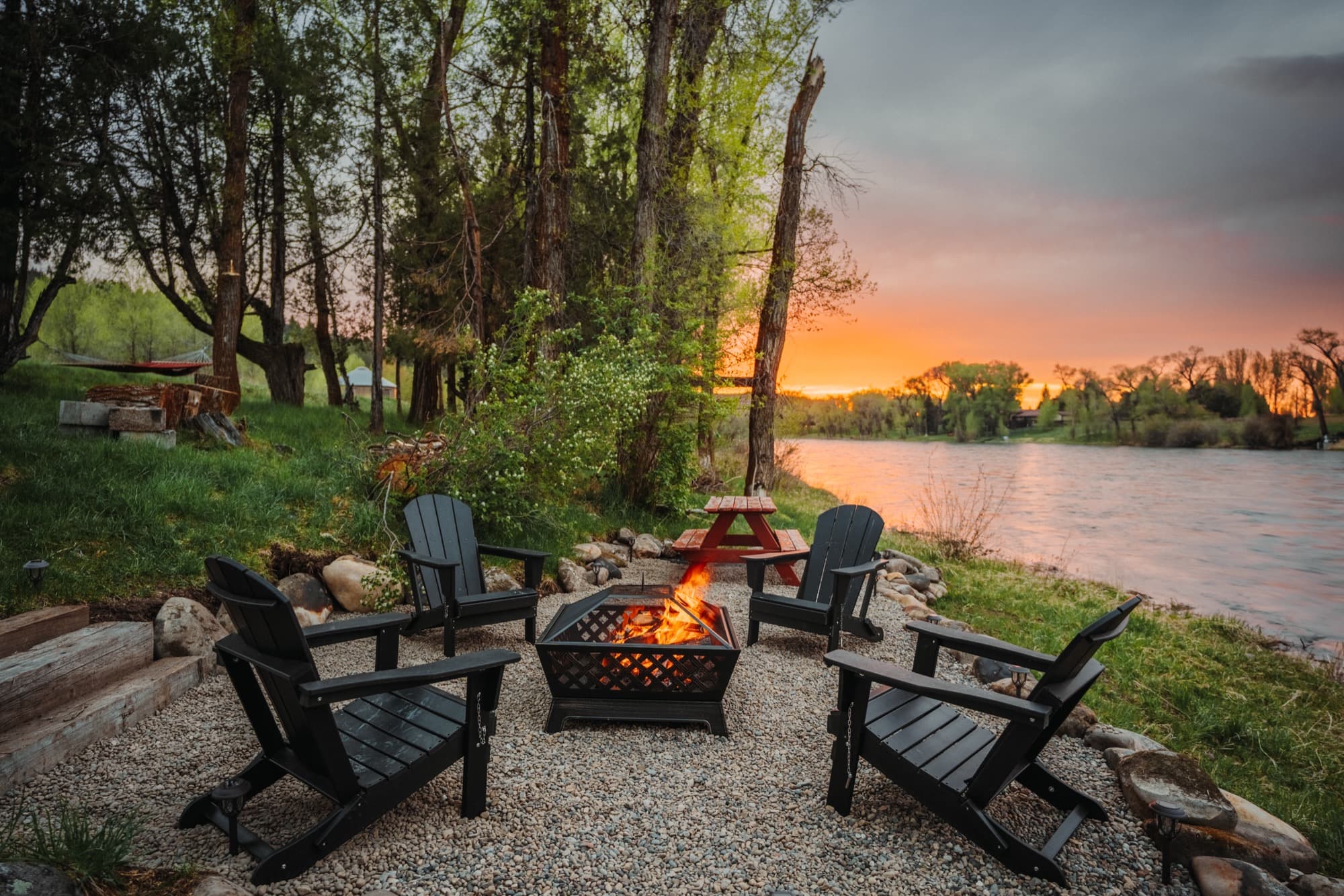 Adirondack chairs around a firepit on the bank of the Snake River at sunset, Swan Valley, Idaho